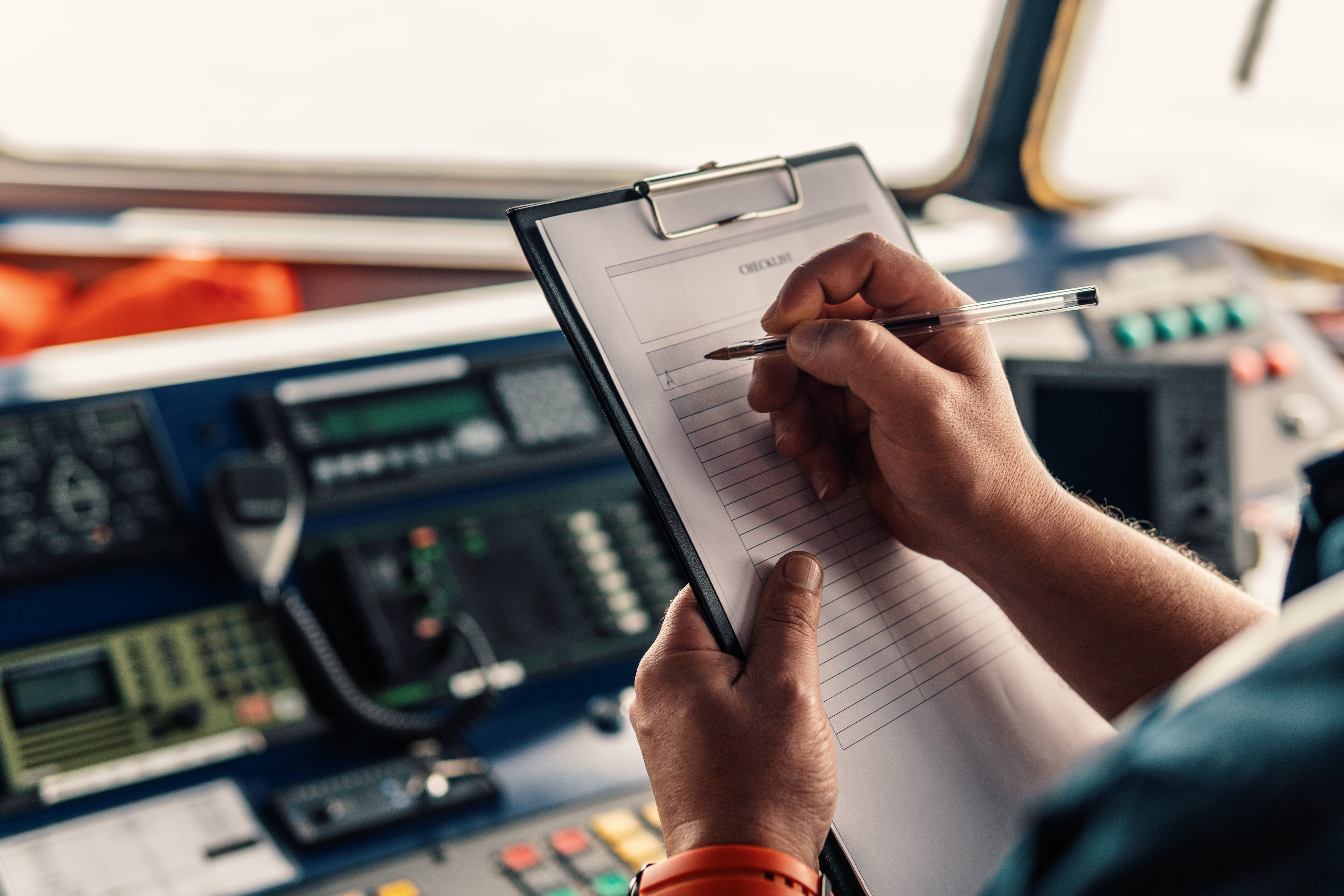 Marine navigational officer or chief mate on navigation watch on ship or vessel. He fills up checklist. Ship routine paperwork